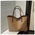 Detalle de un bolso tote de cuero marrón grabado con textura y remaches dorados - Caqui