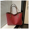Detalle del bolso tote rojo trenzado con asa de cuero marrón y remaches dorados - Rojo