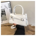 Detailed shot of white square handbag with bow accent and crossbody metal hardware - White