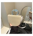 Detail of saddle bag with beige straw texture and silver metallic wavy handle - White