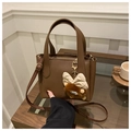 Dettaglio della borsa a secchiello in pelle martellata marrone con ciondolo peluche - Con Ciondolo / Marrone
