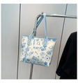 Detailed view of the cartoon graffiti print on this ivory canvas tote bag with blue trim - Blue