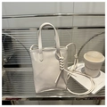 Detail of minimalist cream tote bag with knots and FASHION BAGS text on silver background - White