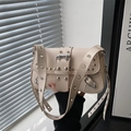 Cremefarbene schicke Nietenschultertasche mit silbernen Ösen und Lederakzenten - Gebrochenes Weiß