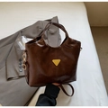 Dettaglio borsa a secchiello in pelle marrone scuro con placca oro e tracolla sottile - caffè