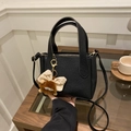 Borsa a secchiello nera con trama litchi, tracolla regolabile e charm in peluche marrone - Con Ciondolo / Nero