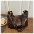 Dettaglio borsa tote in pelle marrone scuro con catena metallica su un tavolo di legno - Con Catena / Caffè