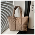 Detalle de bolso tote acolchado en tono tierra con textura suave y asa acolchada fina - Caqui