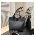 Close-up of a black leather tote bag featuring a Fashion label and elegant knot handle detail - Black