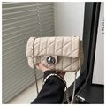 Close-up of cream quilted chain bag with silver twist lock and classic woven strap detail - Khaki