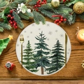 Mantel individual redondo de lino navideño con pinos sobre mesa de madera rústica - Estilo Tres Pinos (XRP094)