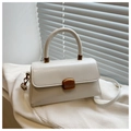 Detail of white structured handbag with gold buckle and PU leather texture on white knit - White