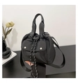 Detalle de un bolso tipo cubo de nailon negro con correa ancha y hebillas metálicas - Negro