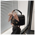 Détail du mini sac seau matelassé avec breloque fleur dorée et ruban imprimé léopard - Grand / Noir