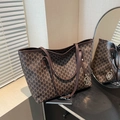 Large brown tote bag with M-letter print pattern and gold pendant on black surface - Brown