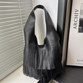 Bolso tote de cuero granulado negro con flecos largos y un diseño minimalista de hombro - Negro