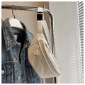 Detail der cremefarbenen Nylon-Gürteltasche mit Gitterstruktur neben Jeansjacke - Weiß