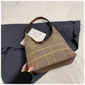 Close-up of vintage brown plaid fabric and leather stitching on the underarm bag - Brown