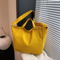 Detail of ginger yellow canvas tote showing wrinkled texture and versatile straps - Yellow