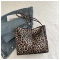 Detailansicht der Leopard-Tragetasche mit langen Riemen auf einer Jeansjacke - Braun