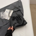 Elegante schwarze Beuteltasche mit Schleifen und Silberkette auf einem Anzug - Schwarz
