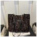 Detail van luipaardprint shopper met gouden ketting en zwart lederen schouderband - Koffie