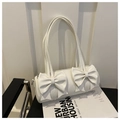 Detalle de un bolso cilíndrico blanco crema con elegantes adornos de lazos en 3D - Blanco