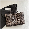 Flat lay of leopard print tote bag on white linen with a blazer and book - Brown