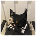 Dettaglio borsa sottobraccio nera increspata con logo giallo e ciondolo a agnello - Nero Con Ciondolo