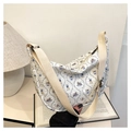 Detail of quilted crossbody bag featuring cute rabbit prints and adjustable strap - White with Blue Rabbit Print