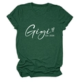Détail de l'imprimé Gigi Est 2026 et du cœur sur un t-shirt vert à manches courtes - Vert Rétro (Police Blanche)