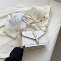 Minimalist beige crossbody small square bag with gold buckle on an elegant office blazer - White