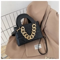 Borsa a tracolla nera trapuntata con catena dorata su uno sfondo di blazer - Nero