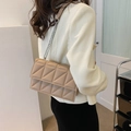 Beige gesteppte Umhängetasche mit Silberkette, präsentiert von einem Damenmodel - Khaki