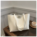 Detail of a white minimalist faux leather tote bag on a glass table with a coffee cup - White