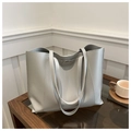 Close-up of light gray tote bag with textured faux leather and silver metal lock detail - Gray