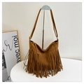 Close-up of caramel suede tote bag featuring bohemian tassels and metal strap buckles - Brown