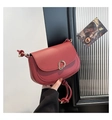 Dettaglio borsa a sella bordeaux con fibbia dorata e tracolla con nodo intrecciato - Rosso