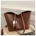 Dettaglio di una borsa tote marrone in finta pelle con ciondolo di peluche su tessuto - Con Ciondolo / Marrone Giallastro