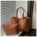 Close-up of brown faux leather tote and matching zipper pouch with gold fashion logo - Brown