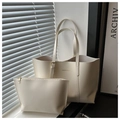 Detail of a minimalist beige tote bag set with adjustable hardware and golden logo - White