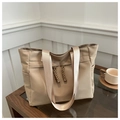 Detail of khaki nylon tote bag with side pocket and woven drawstring on wooden table - Khaki