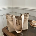 Large khaki canvas tote bag with woven rope detail and side pockets on a coffee table - Khaki