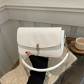 Minimalist white PU leather shoulder bag with gold clasp and chain strap held by model - White