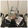 Details der silbernen Stepptasche mit goldener Hardware auf einem Buch platziert - Silber