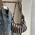 Borsa tote in maglia a righe nere e crema con tracolla appesa a un supporto - Blu