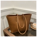 Detalle de un bolso tote de cuero marrón con patrón de lichi sobre mesa de cristal - Marrón