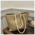 Primer plano de bolso tote de cuero crema con textura lichi sobre mesa de madera - Caqui