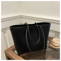 Vista detallada del bolso tote de cuero granulado negro colocado sobre una mesa de madera - Negro