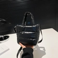 Close-up of black quilted puffer mini tote with adjustable crossbody strap and soft texture - Black